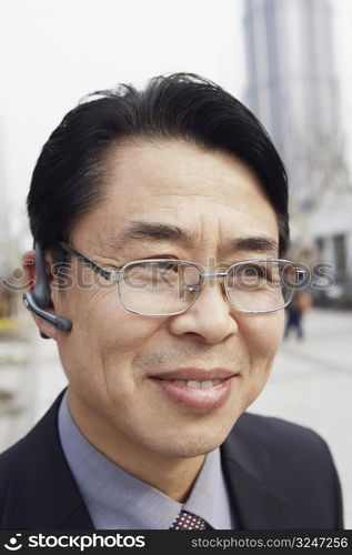 Close-up of a businessman wearing a hands free device smiling