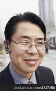 Close-up of a businessman wearing a hands free device smiling