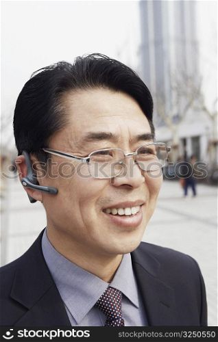 Close-up of a businessman wearing a hands free device smiling