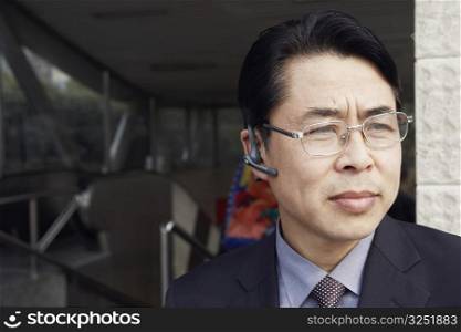 Close-up of a businessman wearing a hands free device thinking