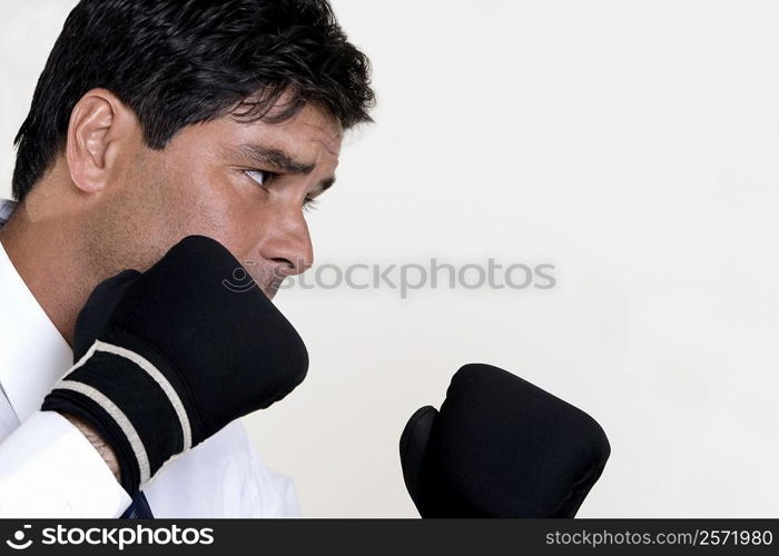 Close-up of a businessman wearing boxing gloves