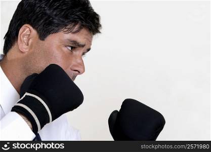 Close-up of a businessman wearing boxing gloves