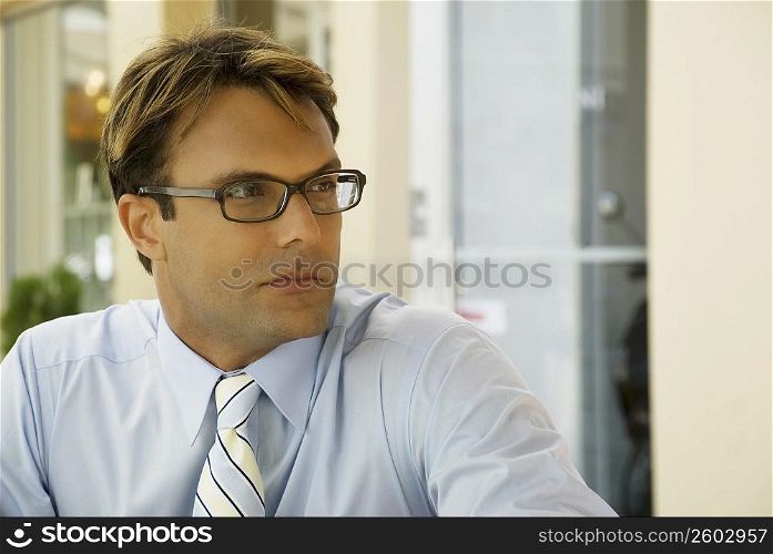 Close-up of a businessman wearing eyeglasses and thinking