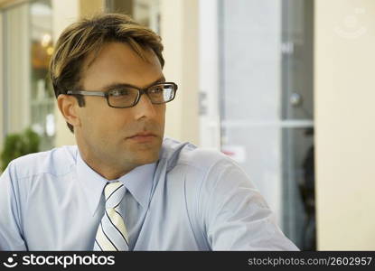 Close-up of a businessman wearing eyeglasses and thinking