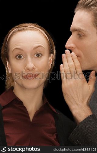 Close-up of a businessman whispering into a businesswoman&acute;s ear