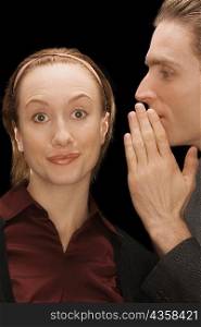 Close-up of a businessman whispering into a businesswoman&acute;s ear