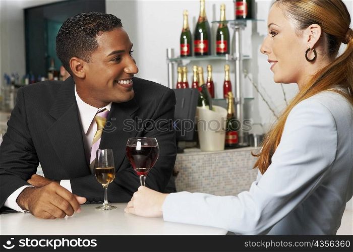 Close-up of a businessman with a businesswoman sitting in a bar
