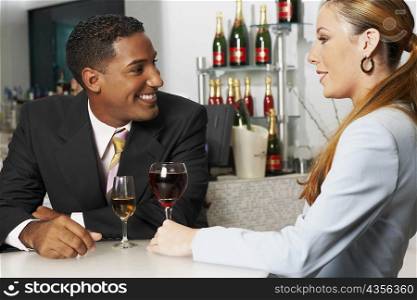 Close-up of a businessman with a businesswoman sitting in a bar