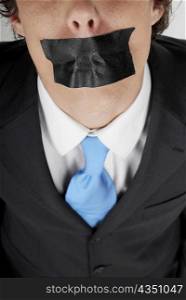 Close-up of a businessman with duct tape on his mouth