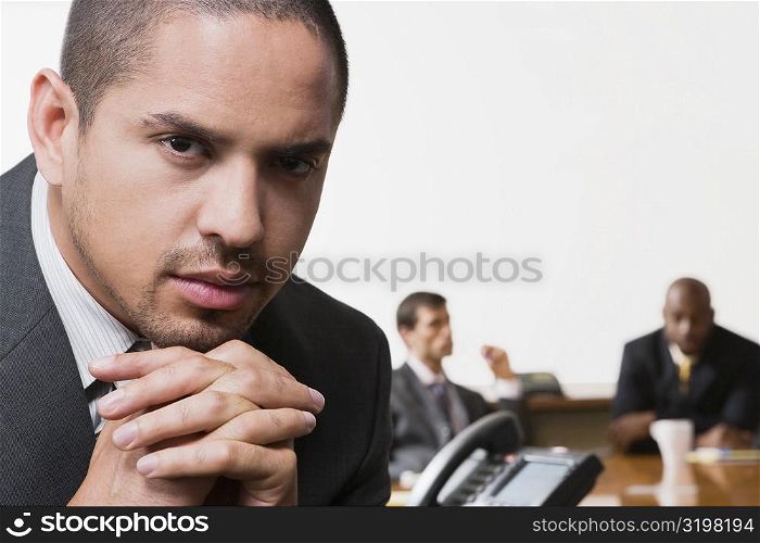 Close-up of a businessman with his colleagues discussing in the background