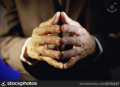 Close-up of a businessman with his fingers together