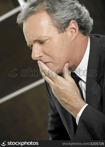 Close-up of a businessman with his hand over his mouth