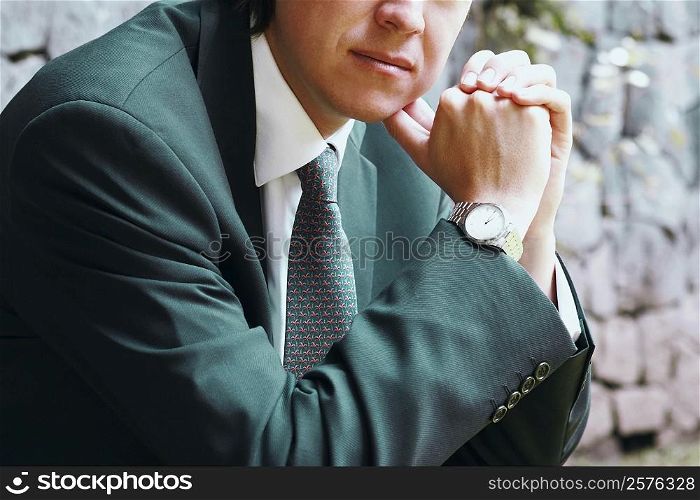 Close-up of a businessman with his hands clasped