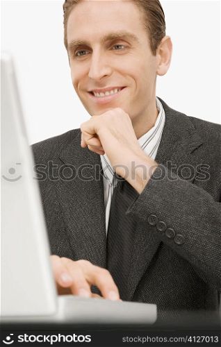 Close-up of a businessman working on a laptop and smiling