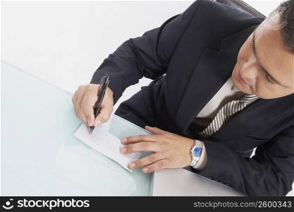 Close-up of a businessman writing a check