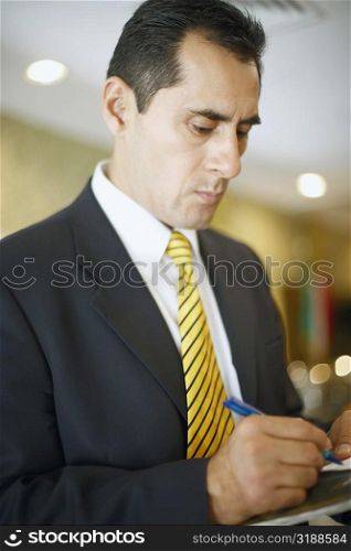 Close-up of a businessman writing on a notepad