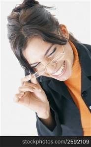 Close-up of a businesswoman adjusting her eyeglasses and smiling