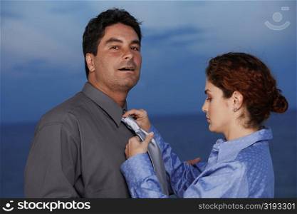 Close-up of a businesswoman adjusting the tie of a businessman