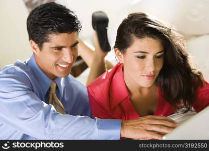 Close-up of a businesswoman and a businessman using a laptop