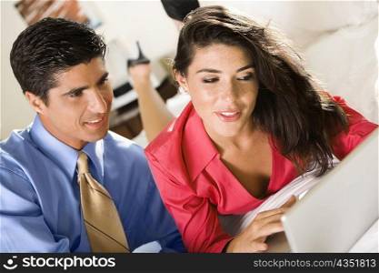 Close-up of a businesswoman and a businessman using a laptop
