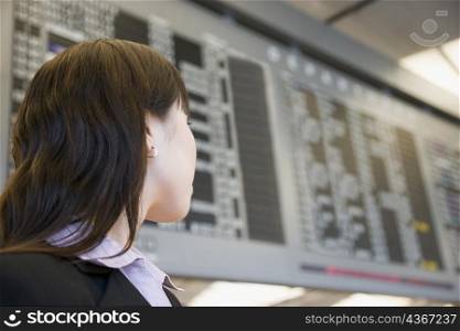 Close-up of a businesswoman at an airport and looking at an arrival departure airport