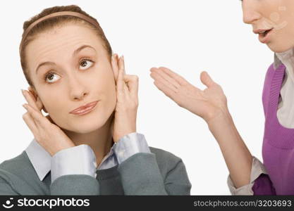 Close-up of a businesswoman covering her ears with fingers