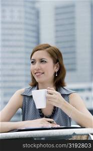 Close-up of a businesswoman drinking coffee at a sidewalk cafe