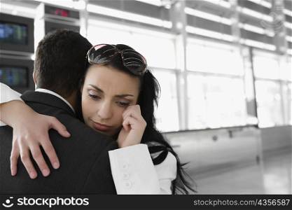 Close-up of a businesswoman embracing a businessman at an airport