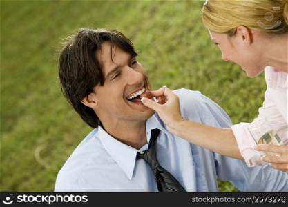 Close-up of a businesswoman feeding a cherry to a businessman