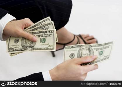 Close-up of a businesswoman giving a twenty dollar bill