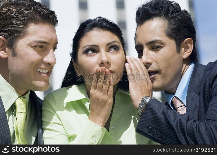 Close-up of a businesswoman gossiping with two businesswomen