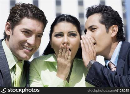 Close-up of a businesswoman gossiping with two businesswomen