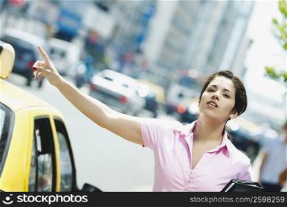 Close-up of a businesswoman hailing a taxi