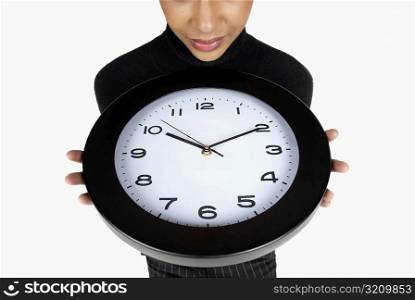 Close-up of a businesswoman holding a clock