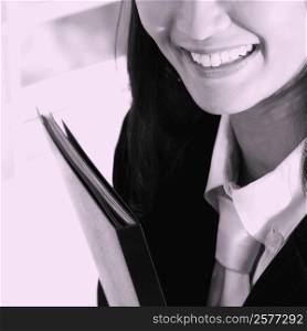 Close-up of a businesswoman holding a file and smiling