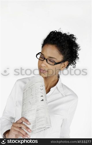 Close-up of a businesswoman holding a financial newspaper with her eyes closed