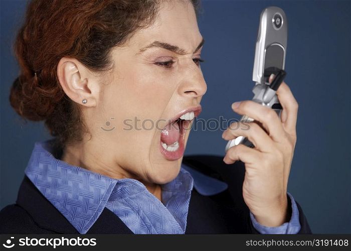 Close-up of a businesswoman holding a mobile phone and shouting