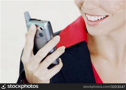 Close-up of a businesswoman holding a mobile phone and smiling