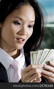Close-up of a businesswoman holding American dollar bills