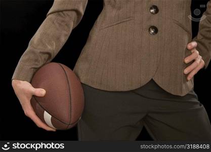 Close-up of a businesswoman holding an American football