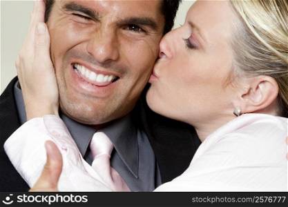 Close-up of a businesswoman kissing a businessman