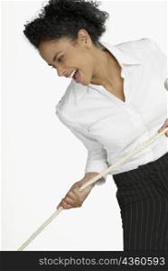 Close-up of a businesswoman pulling a rope and laughing