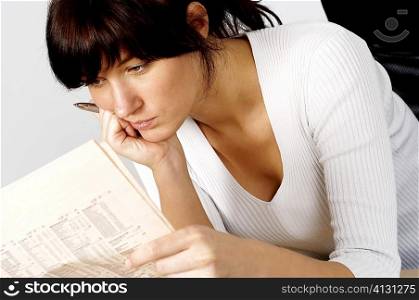 Close-up of a businesswoman reading a financial page