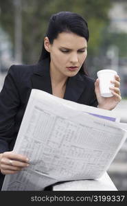 Close-up of a businesswoman reading a newspaper