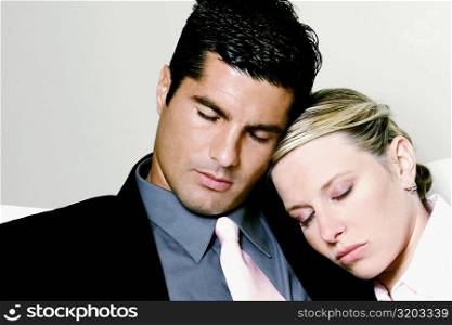 Close-up of a businesswoman resting her head on a businessman&acute;s shoulder