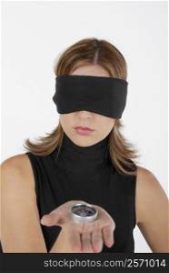 Close-up of a businesswoman showing a compass with her eyes blindfolded