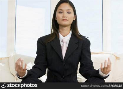 Close-up of a businesswoman sitting in the lotus position