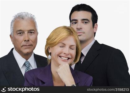 Close-up of a businesswoman smiling with two businessmen behind her