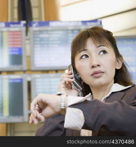 Close-up of a businesswoman talking on a mobile phone and checking the time