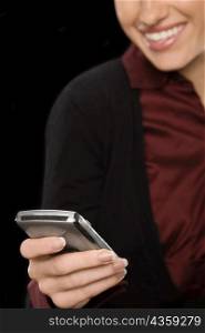 Close-up of a businesswoman text messaging and smiling